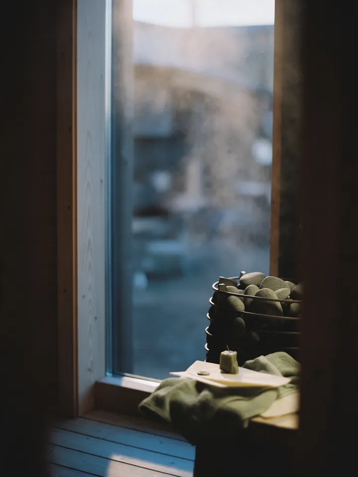 A tall window at blue hour with rain on the glass and the world beyond soft and cool. An illustration made for this page.